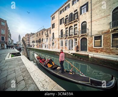 Rio San Barnaba, Venedig. Gondeln gleiten vorbei an verwittertem Ziegelstein und klassischem Stein – Dorsoduros ruhiger Kanal, wo Obstkähne anlegen und Schatten verweilen Stockfoto