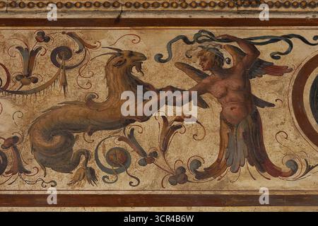 Halb Mensch, halb Vogel und halb Ziege, halb Fisch: Mythische Hybridwesen, ein androgyner geflügelter Mensch und das astrologische Steinbock-Symbol, eine Meerziege oder Ziegenfische, in typischer Spätrenaissance Mitte der 1500er Jahre n. Chr., manieristische Grotesken Fresko im ersten Hof oder Cortile di Michelozzo des Palazzo Vecchio, mittelalterliches Rathaus der Piazza della Signoria, Florenz, Toskana, Italien. Stockfoto