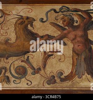 Ein Meeresziegen- oder Ziegenfisch, das Steinbock-Zodiakal-Symbol, steht vor einem androgynen, teilmenschlichen, teilvogelförmigen Tier: Mythische Hybriden in der typischen Spätrenaissance, Mitte der 1500er Jahre, manieristische Grotesken Fresko im ersten Hof oder Cortile di Michelozzo des Palazzo Vecchio, mittelalterliches Rathaus auf der Piazza della Signoria, Florenz, Toskana, Italien. Stockfoto