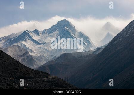 Schneebedeckte Berge unter bewölktem Himmel mit rauem Gelände im Vordergrund. F042, Annapurna, Mustang District, Provinz Gandaki, Nepal Stockfoto