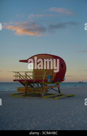 Farbenfroher Rettungsschwimmer-Turm an einem Sandstrand bei Sonnenuntergang mit pastellfarbenem Himmel. Miami, Florida, USA Stockfoto