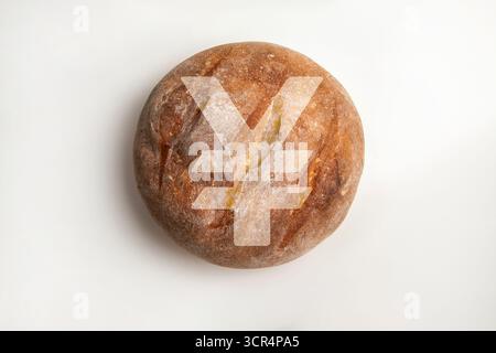 Yen- oder Yuan-Währungssymbol auf einem Brotlaib. Stellt steigende Lebensmittelkosten, Inflation und wirtschaftliche Herausforderungen in einem asiatischen Kontext dar. Stockfoto