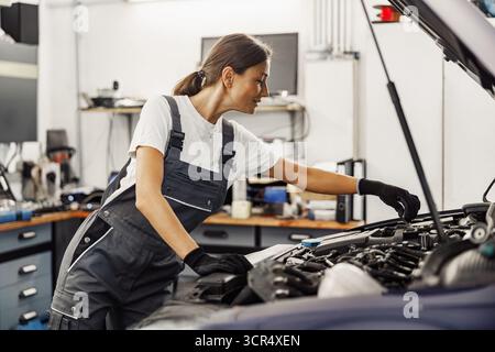 Ein Mechaniker, der geschickte detaillierte Motorwartungsaufgaben im Werkstattbereich durchführt Stockfoto