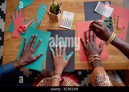 Black Family: Kwanzaa-Bastelarbeiten gemeinsam mit Papier und Schere Stockfoto