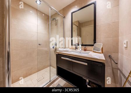 Modernes Badezimmer Innenausstattung mit bodenebener Dusche und Kosmetikspiegel im Ferienhaus Stockfoto