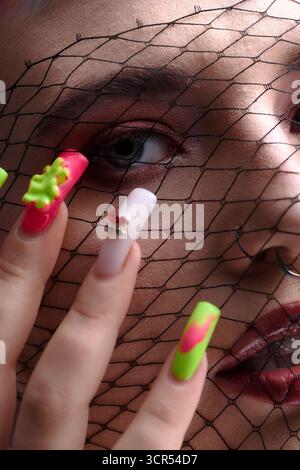 Eine junge Frau mit bunten kurzen Haaren zeigt ihre einzigartige Schönheit in einem künstlerischen Atelier. Stockfoto
