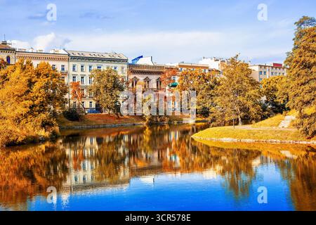 Wunderschöne Herbststadt mit bunten Bäumen, die sich im Wasser spiegeln, und historischen Gebäuden Stockfoto