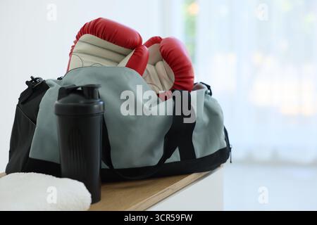 Stilvolle Tasche mit Sportausrüstung auf Holztisch zu Hause Stockfoto