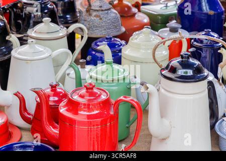 Vintage Emaille Teekessel in verschiedenen Farben auf einem Flohmarkt Stockfoto