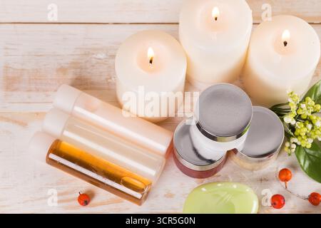 Bio-Hautpflegeprodukte, natürliche Kerzen und frische Zutaten auf einem Holztisch Stockfoto