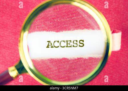 Das ZUGANGSWORT wurde mit einer Lupe unter einem Blatt Papier gefunden. Cybersicherheit und Verschlüsselungskonzept. Stockfoto