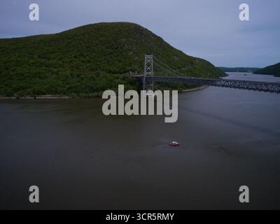 Aus der Vogelperspektive die Bear Mountain Bridge, die sich über den Hudson River erstreckt, mit üppigen grünen Bergen im Hintergrund, New York, USA. Stockfoto