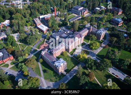 Blick aus der Vogelperspektive auf Backsteinhäuser mit roten Dächern, eingebettet zwischen lebhaften grünen Bäumen und gepflegten Rasenflächen, die eine malerische Campus-Umgebung schaffen, Vassar Col Stockfoto