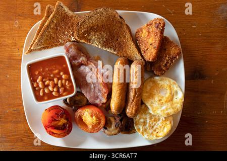 Ein traditionelles englisches Frühstück wird serviert. Dieses englische Restaurant bietet Würstchen, Speck, gegrillte Tomaten, gebratene Pilze, Spiegeleier und mehr. Stockfoto