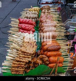 Gemischte Grillspieße mit Schweinefleisch, Würstchen und Fischbällchen auf Bananenblättern am Thai Street Stand. Traditionelle Street Food-Küche. Stockfoto