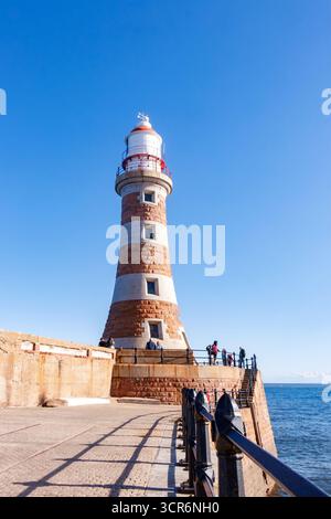 Hoher Roker Pier Leuchtturm mit roten und weißen Streifen am Meer an einem sonnigen Tag mit tiefblauem Himmel im Hintergrund Sunderland Stockfoto
