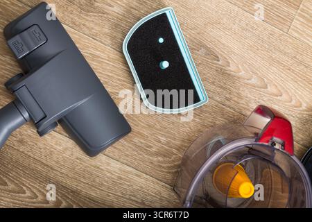 Reinigungswerkzeuge, die tagsüber auf Holzboden in einer aufgeräumten Wohnumgebung angeordnet sind Stockfoto