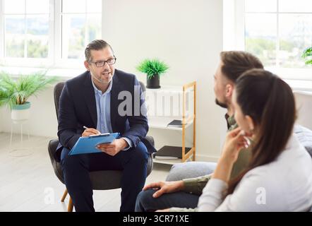 Familienpaare Bei Treffen Mit Versicherungs- Oder Finanzberater Stockfoto