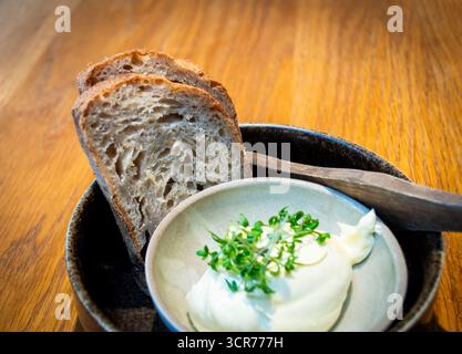 Zwei Scheiben Sauerteigbrot mit Butter an einem Esstisch in einem lokalen Restaurant in Norwegen Stockfoto