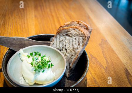 Zwei Scheiben Sauerteigbrot mit Butter an einem Esstisch in einem lokalen Restaurant in Norwegen Stockfoto