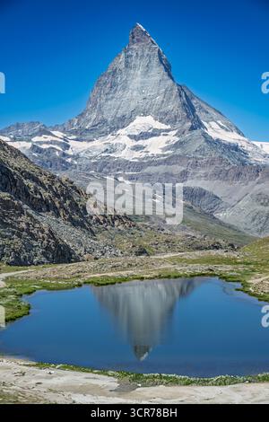 Ein atemberaubender Blick auf das Matterhorn, einen der berühmtesten Gipfel der Alpen, spiegelt sich im ruhigen Wasser des Riffelsees bei Zermatt, Swit Stockfoto
