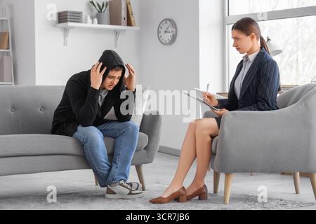 Männlicher Drogenabhängiger, der Psychologe im Büro besucht Stockfoto