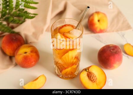 Serviette und Glas leckeren Pfirsicheistees auf Marmorhintergrund, Nahaufnahme Stockfoto