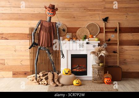 Innenraum des festlichen Wohnzimmers mit Leiter, Spooky Halloween Monster, Couchtisch und Herbstdekoration am Kamin Stockfoto