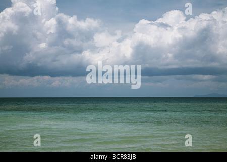 Weit keine Menschen vor dem Sturm vom ruhigen Ozean geschossen. Malerischer Blick auf das weite, ruhige Meer in verschiedenen Farben von türkis bis tiefblau am bewölkten Nachmittag Stockfoto