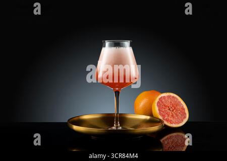 Cocktail mit Orange und Grapefruit auf schwarzem Hintergrund. Klassische und moderne Cocktails – Mojito, Margarita, Martini und mehr Stockfoto