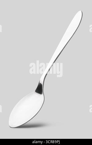 Poliertes Edelstahl-Geschirr Dessertlöffel isoliert neutraler grauer Hintergrund, luxuriöses Restaurant-Utensilien aus Metall in Nahansicht Stockfoto