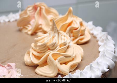 Die Konditorin gießt mit dem Gebäckbeutel, Nahaufnahme, Creme auf den Biskuitkuchen. Konditor ist Kochen hausgemachten Kuchen. Kochen, Backen und Kochen, Stockfoto