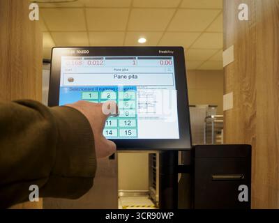 Cremona, Italien – 31. August 2025 Kunde nutzt die Schnittstelle für Selbstkauf-Kassen für Lebensmitteleinkäufe in einem preisgünstigen Supermarkt mit Digitalbildschirm Stockfoto