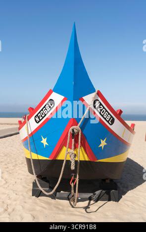 Vorderansicht des Bugs eines hell dekorierten Fischerbootes am Strand von Nazaré, Portugal Stockfoto