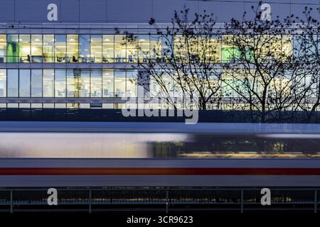 Bürogebäude in der Nacht. Davor ein vorbeifahrender ICE-Zug der Deutschen Bahn AG. Stuttgart, Baden-Württemberg, Deutschland Stockfoto