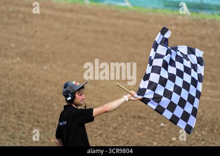 Motocross, Rudersberg, Baden-Württemberg, Deutschland, Europa, Mann, der eine schwarz-weiß karierte Flagge auf einem trockenen Feld schwenkt, Rudersberg Motocross Stockfoto