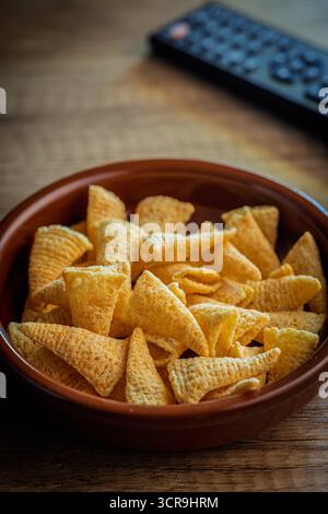 Snack mit Bugles. Kegel Maischips in einer Schüssel auf einem Holztisch. Stockfoto