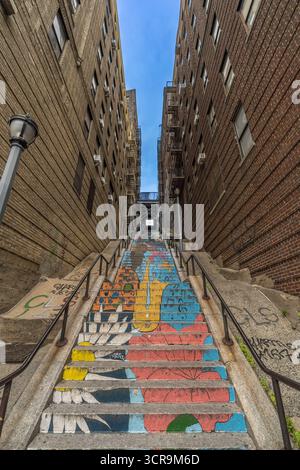 Farbenfrohe gemalte Stufen an der berühmten Joker Treppe in der Bronx, New York City, zwischen Wohngebäuden. Juni 2025. Stockfoto