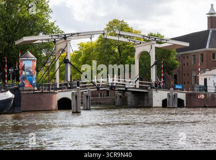 Amsterdam, Niederlande - 5. August 2025: Eine Zugbrücke in Amsterdam steht offen, sodass Boote vorbeifahren können. Stockfoto