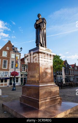 Delft, Niederlande, 27. August 2025. Bronzestatue von Hugo Grotius vor der Neuen Kirche. Weites, flaches Bild, sonniger Sommertag, kein P Stockfoto