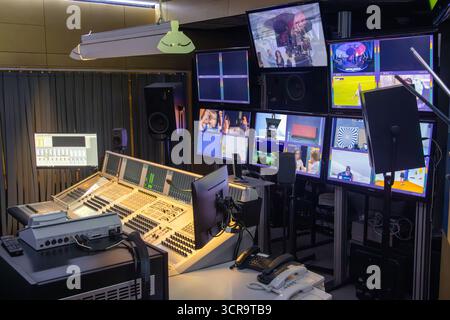 Innenansicht eines voll ausgestatteten Sendestudios mit mehreren Bildschirmen und Bedienkonsolen. Stockfoto
