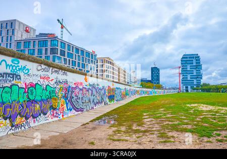 BERLIN, DEUTSCHLAND - 3. OKTOBER 2019: Die Überbleibsel der Berliner Mauer mit zahlreichen Bildern, bekannt als der East Side Gallery, am 3. Oktober in Berli Stockfoto