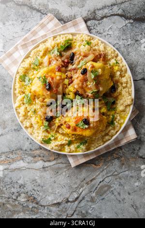 Herzhaft süß duftende Huhn Couscous Tfaya ist eine beruhigende und besondere Mahlzeit aus der Nähe auf dem Teller auf dem Tisch. Vertikale Draufsicht von oben Stockfoto