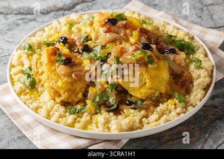Huhn Couscous Tfaya mit karamelisierter Zwiebel und Rosinen Nahaufnahme auf dem Teller auf dem Tisch. Horizontal Stockfoto
