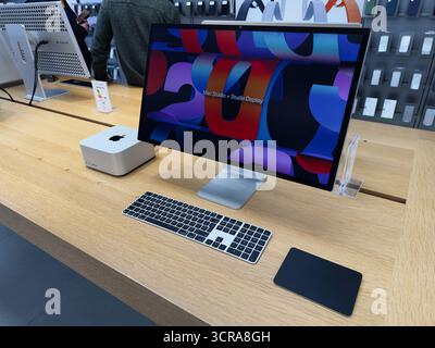Manchester, Großbritannien - 29. September 2025: Moderner Apple Mac Studio Computer auf einem Holztisch mit großem Monitor und Tastatur in einem Ausstellungsraum. Stockfoto
