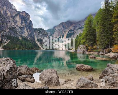 Idyllischer und ruhiger Pragser Wildsee. Malerisches türkisfarbenes Wasser, Felsen, Bäume und bewölkter Himmel. Dolomiten, Italien Stockfoto