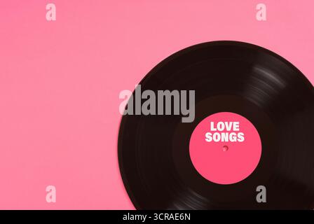 Vinyl-Platte mit rosa Label, das Liebeslieder auf rosa Hintergrund anspricht, perfekt für Projekte im Zusammenhang mit Musik, Romantik oder valentinstag Stockfoto