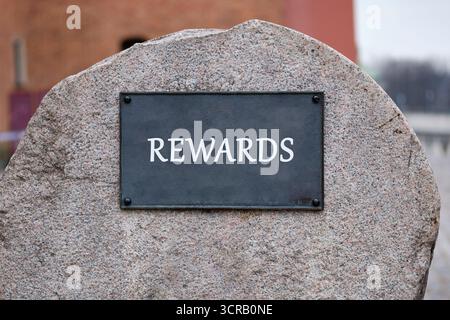 Geschäfts- und Risiko- oder Vergütungskonzept. Kopierbereich. BELOHNUNGEN auf der Tafel eines großen Steindenkmals Stockfoto