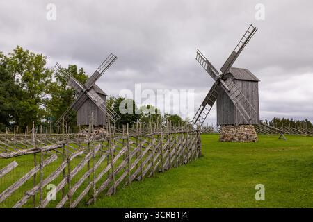 Eine traditionelle Windmühlen aus Holz auf einem Steinfuß steht umgeben von einem Holzzaun auf dem Land. Saaremaa, Estland. Stockfoto