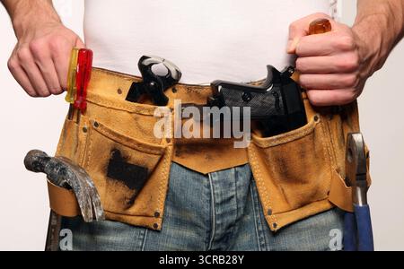 Handlicher Mann mit Ledergürtel und Pistole Stockfoto